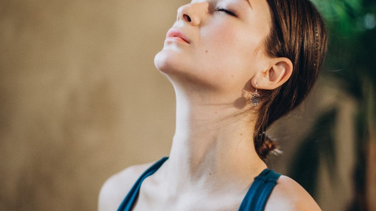 Femme aux yeux fermés, la tête légèrement renversée, dans un moment de détente