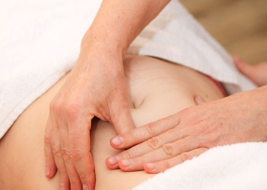 Massage doux du ventre, mains posées sur l'abdomen